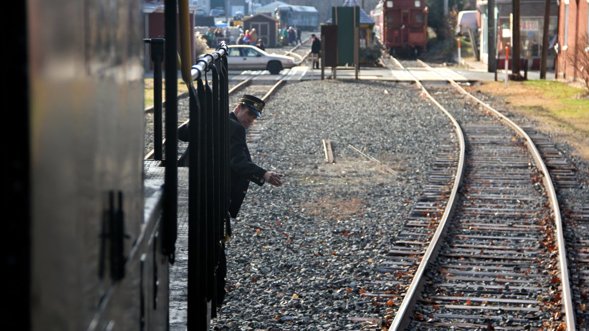 Conductor Nathaniel guests guides the engine driver he approaches a road. (Emma Lee/WHYY)