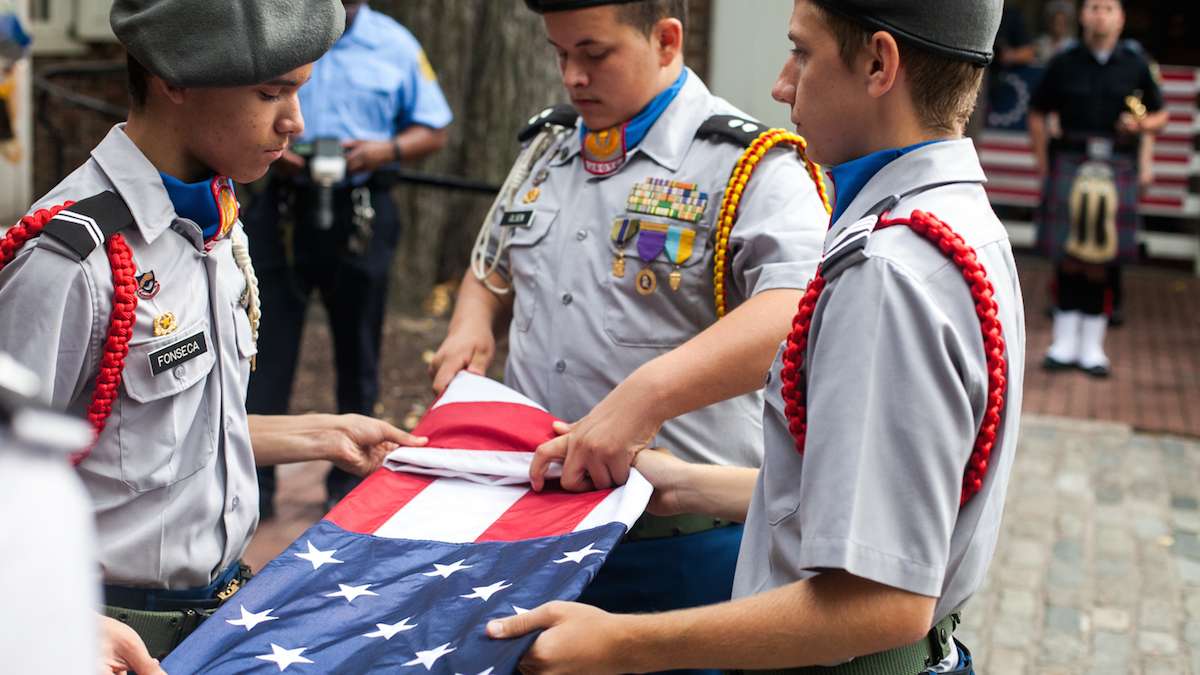 Members of the Frankford High School ROTC Program fold a flag to honor fallen police and firefighters on September 11, 2016.