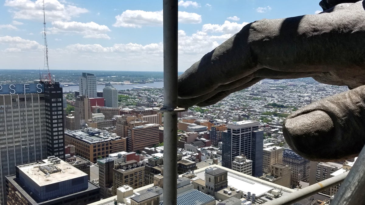 The hand of William Penn hovers above Philadelphia, a view made possible by scaffolding that has been erected to clean and repair the statue atop City Hall. (Peter Crimmins/WHYY)