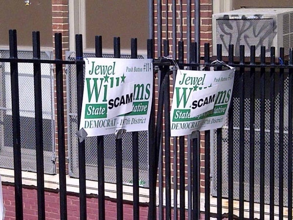 <p><p>47.  A group of people plastered Jewel Williams signs outside of Mifflin Elementary with stickers reading "Scam" (Brian Hickey/WHYY)</p></p>
