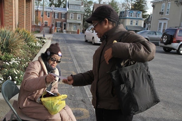 <p><p>Democratic committeeperson Ms. Grey gives literature to Doreen Esnard. (Trenae V. McDuffie/for NewsWorks)</p></p>
