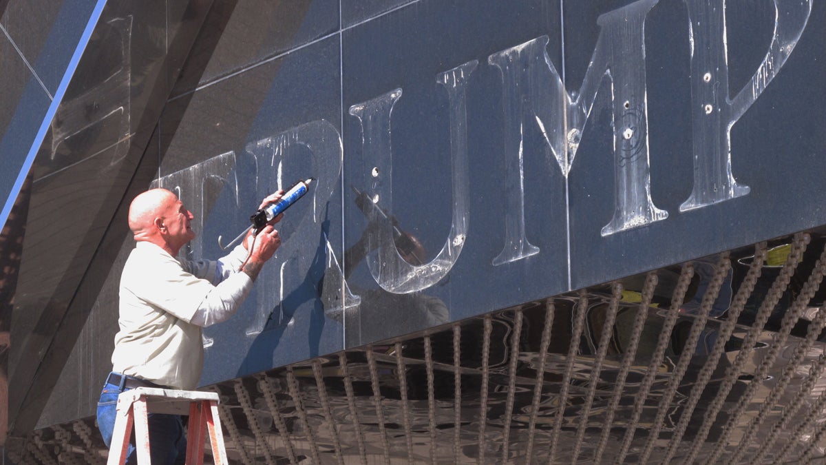  In this Oct. 6, 2014 photo, a worker applies caulk to holes in the facade of the former Trump Plaza casino in Atlantic City N.J (AP Photo/Wayne Parry) 