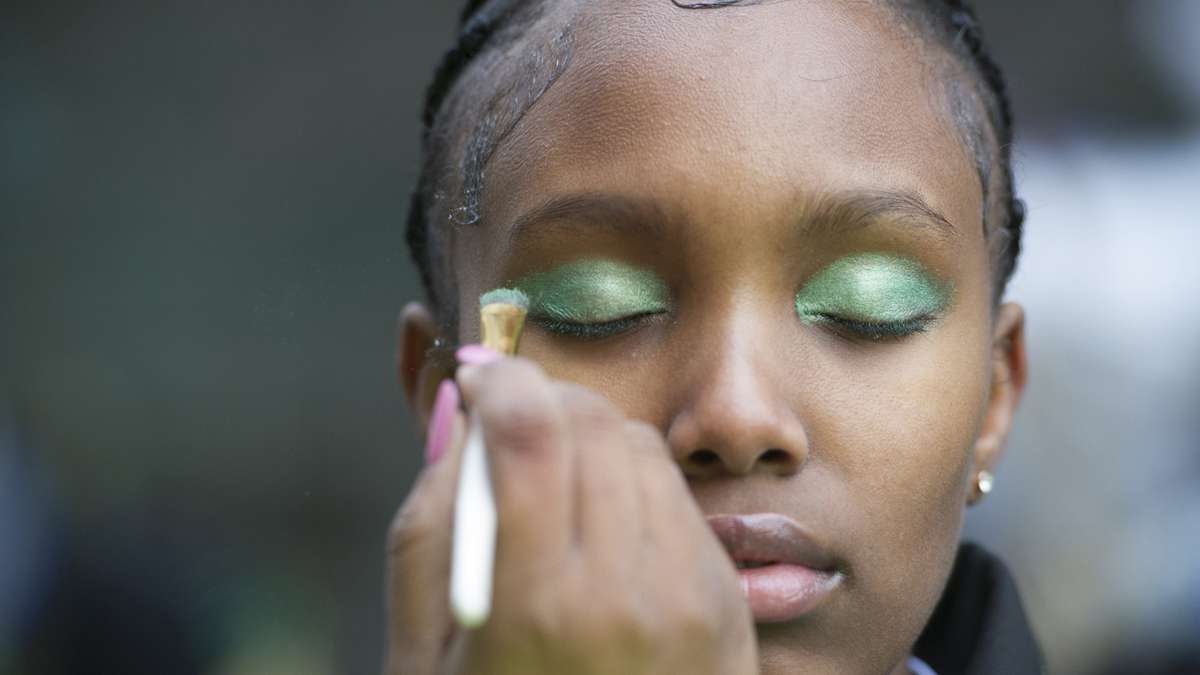 A member of the Second 2 None Drill Team is made up prior to the parade. (Jonathan Wilson/for NewsWorks)