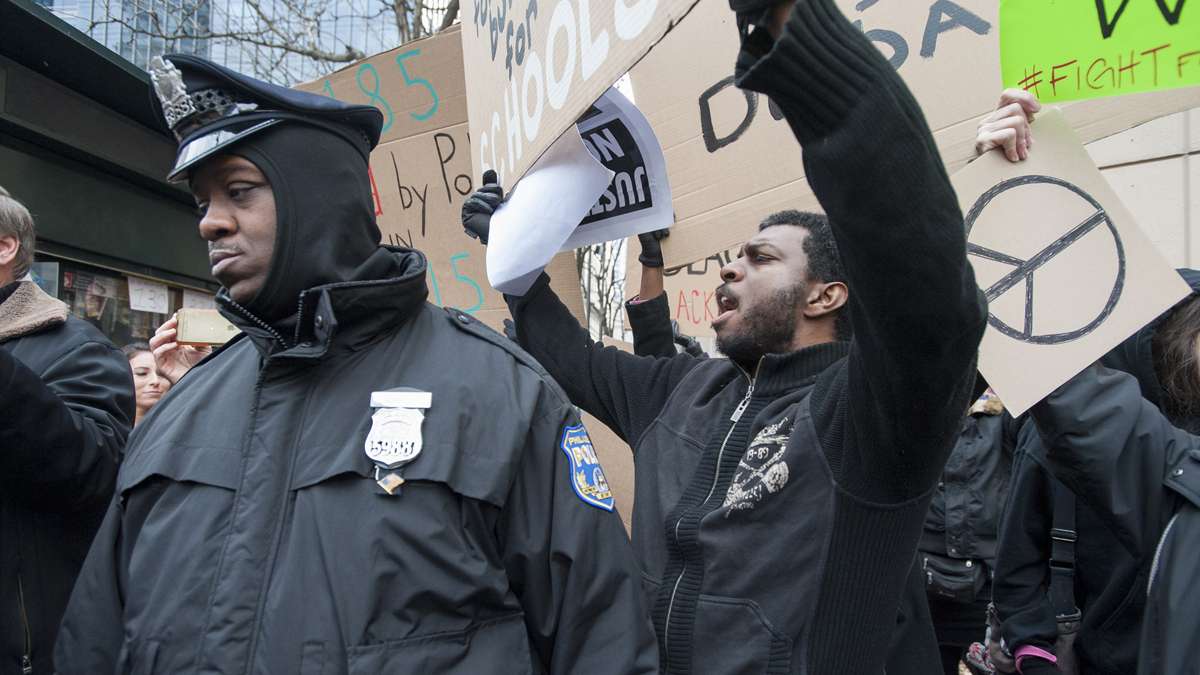 Demonstrators from Black Lives Matter protest on the sidewalks adjacent to the parade. (Jonathan Wilson/for NewsWorks)