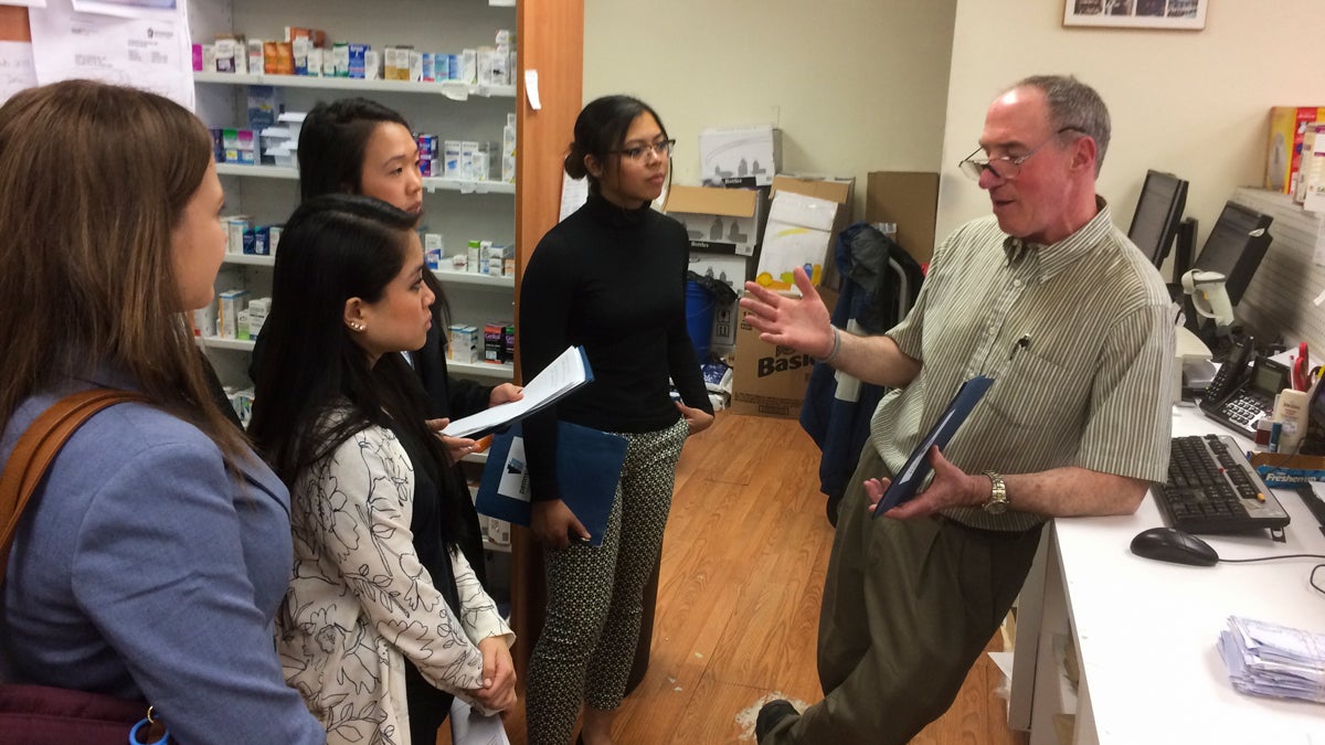 Students and faculty from the Philadelphia College of Pharmacy answer questions about filling orders for Naloxone from David Ostrow at Cambria Pharmacy in Fairhill. (Joel Wolfram/for NewsWorks) 