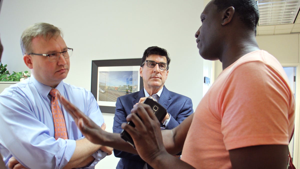  Black Lives Matter activist Asa Khalif (right) confronts Managing Director Michael DiBerardinis (center) and Deputy Managing Director Brian Abernathy at their office to demand that the city investigate the fatal police shooting of David Jones on June 8. (Emma Lee/WHYY) 