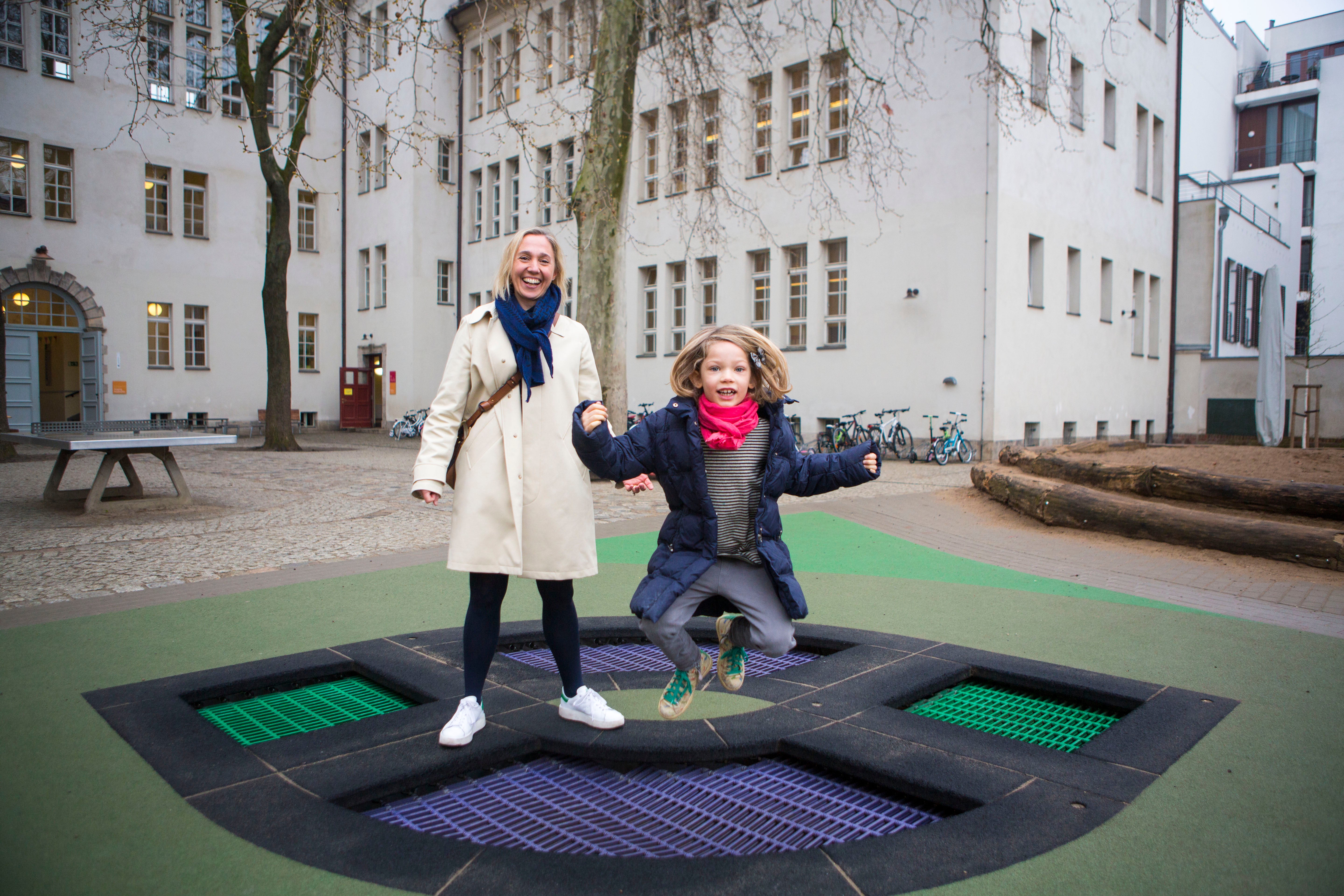 Anke Krause (left) with her daughter Mia in the playground at Koppenplatz elementary where both her daughters attend. (Jessica Kourkounis/For Keystone Crossroads)