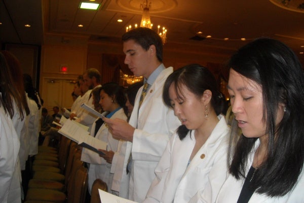 First-year students stand to take the Oath of Hippocrates during the White Coat Ceremony for the Drexel University College of Medicine.
