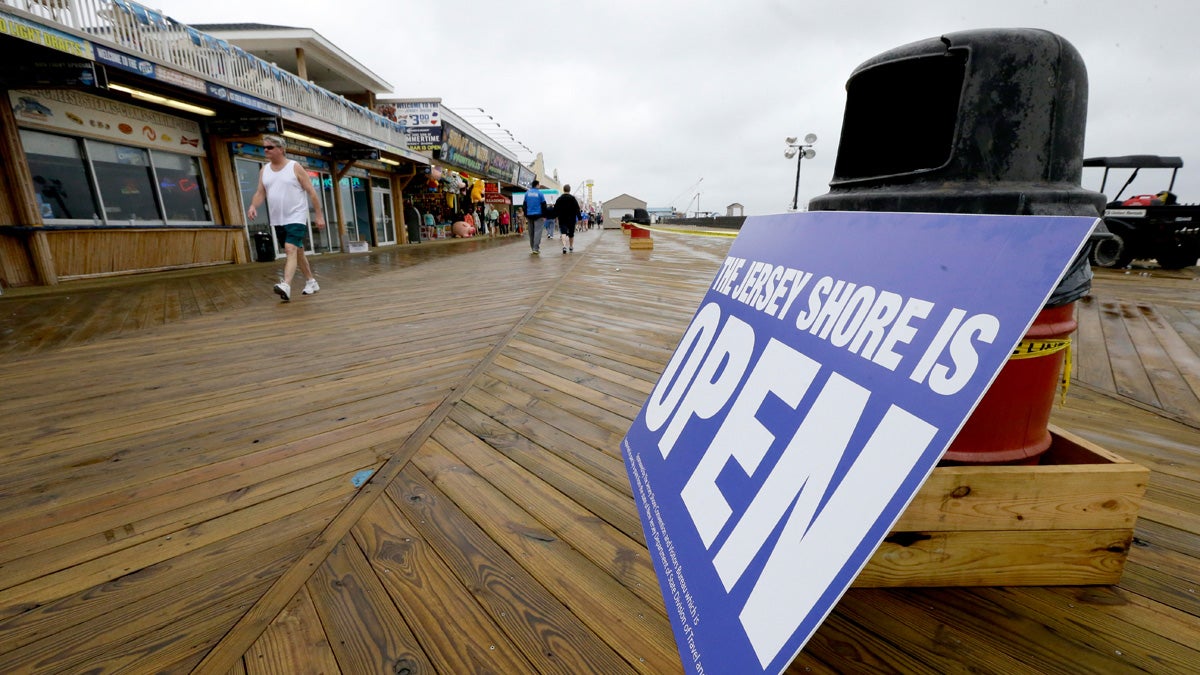  A sign rests on a trash can as people walk on the boardwalk, in Seaside Heights, The N.J. Business Association says business is down because potential visitors aren't aware that most of the restaurants have reopened. (AP Photo/Julio Cortez, file) 