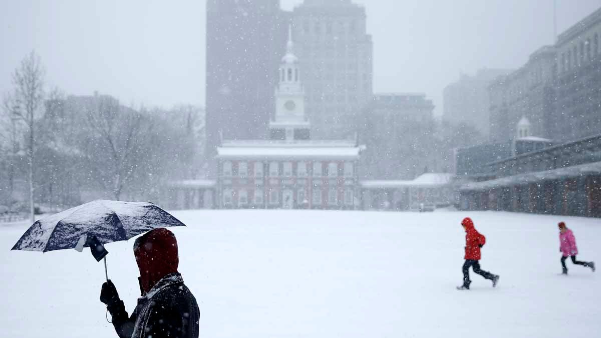  Pedestrians pass Independence Hall  in Philadelphia during a March storm. The city exceeded its snow removal budget by $1.2 million. (AP file photo) 