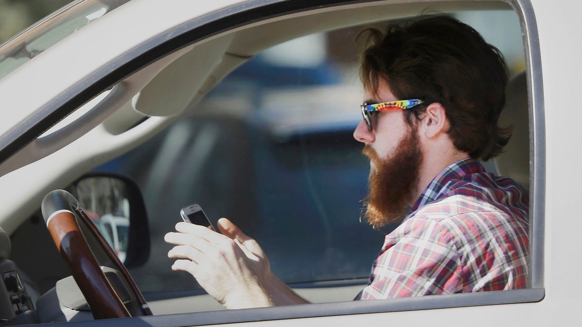  An man works his phone as he drives through traffic in Texas. Proposed legislation would allow police in New Jersey to search the cell phones of drivers involved in accidents to determine if they were texting or talking at the time of a crash. (AP Photo/LM Otero) 