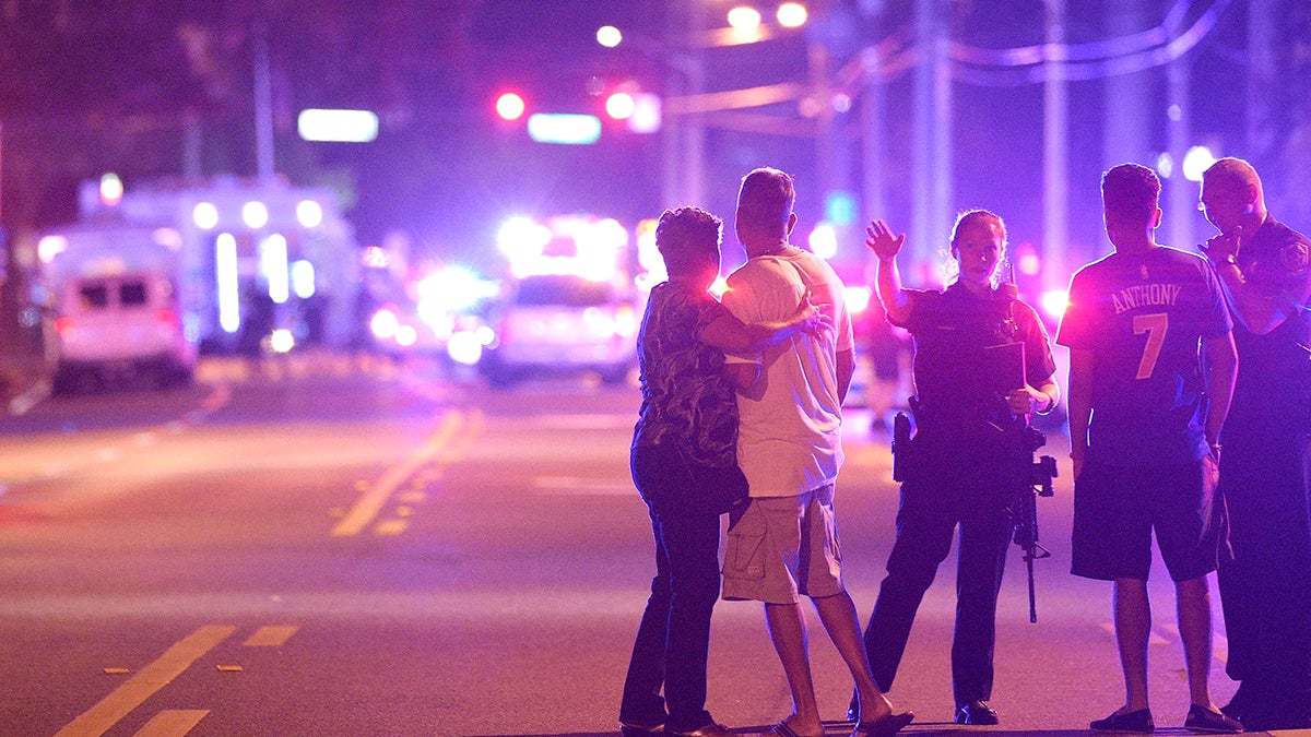 Orlando Police officers direct family members away from a fatal shooting at Pulse Orlando nightclub in Orlando