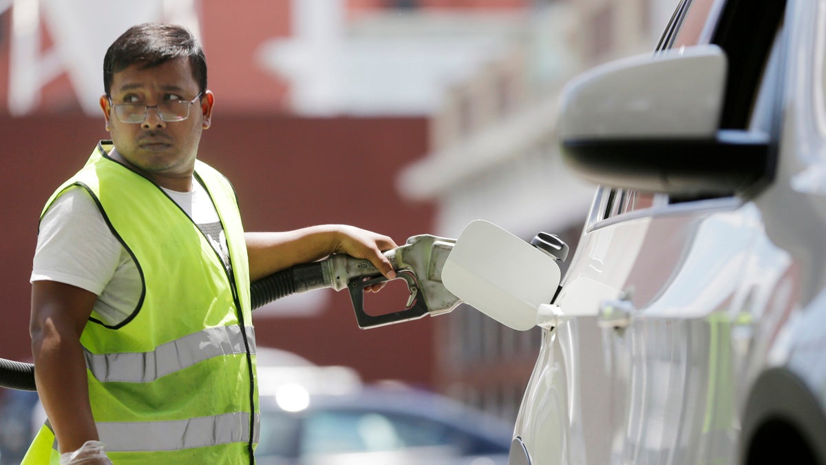 Shafigul Azim pumps gas for a motorist at a BP gas station in Hoboken