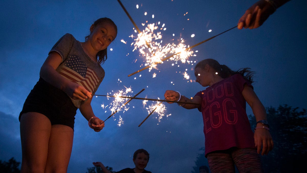  Children celebrate Fourth of July in Cincinnati last year. New Jersey lawmakers are considering allowing those 16 and older to buy and use sparklers. (AP file photo) 