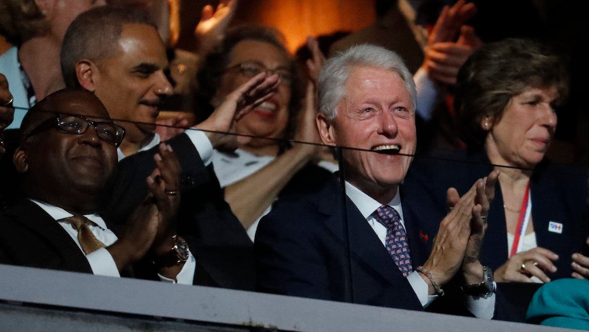 Former President Bill Clinton applauds as First Lady Michelle Obama speaks during the first day of the Democratic National Convention in Philadelphia