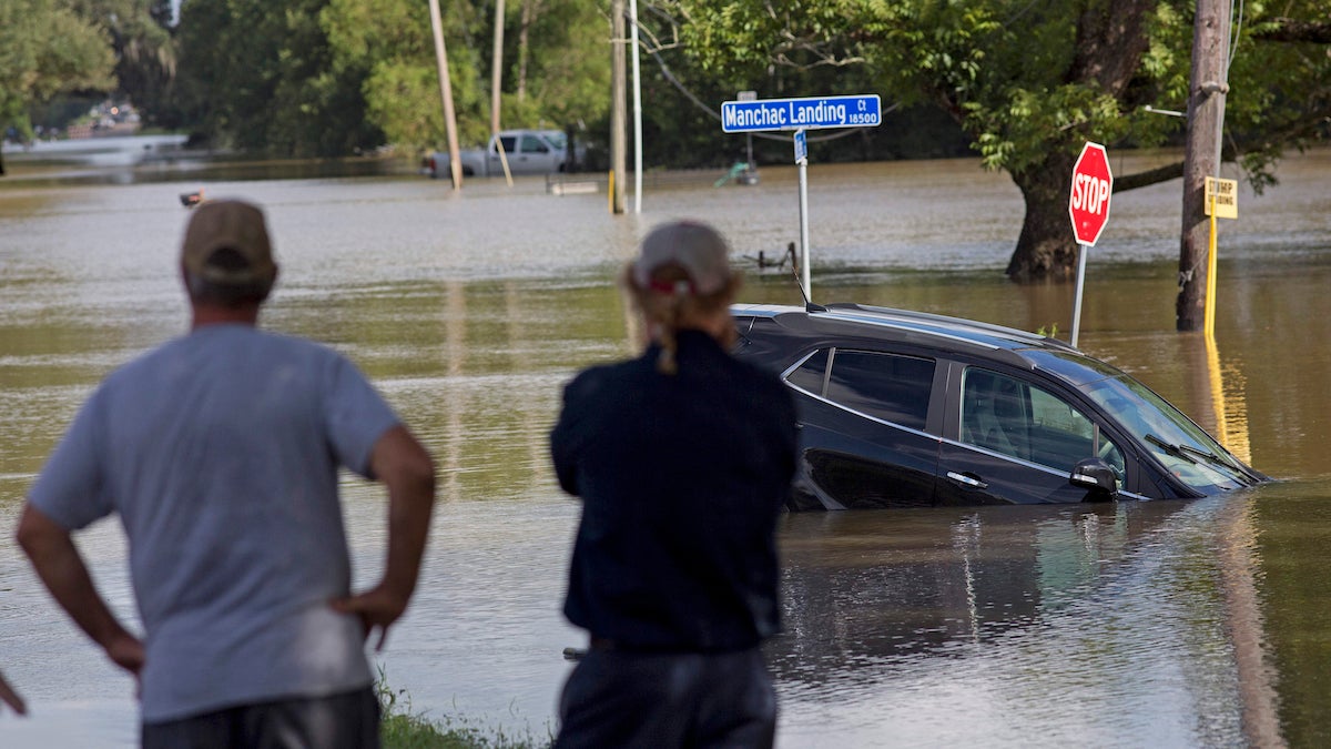  Prairiesville, Louisiana,  residents last month survey the flood water on Old Jefferson Highway. The flooding killed at least 13 people, damaged 150,000 homes and cost at least $8.7 billion. (AP Photo/Max Becherer, File) 