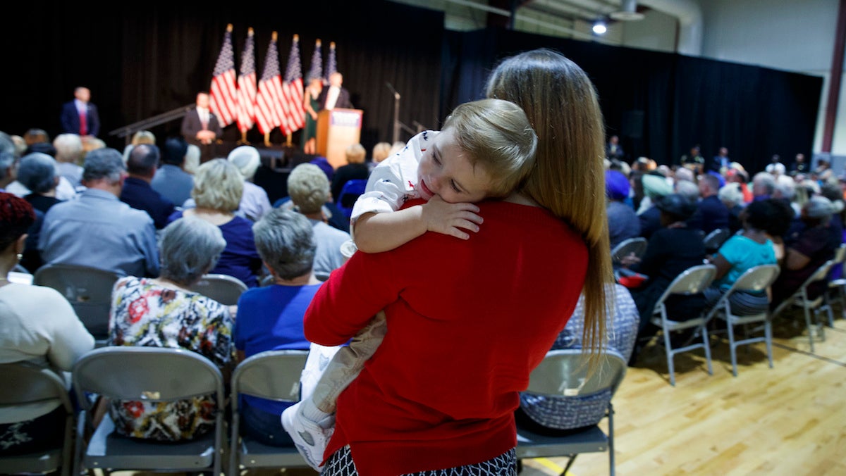 A woman holds her child as Republican presidential candidate Donald Trump delivers a policy speech on child care, Tuesday, Sept. 13, 2016, in Aston, Penn. (AP Photo/Evan Vucci) 