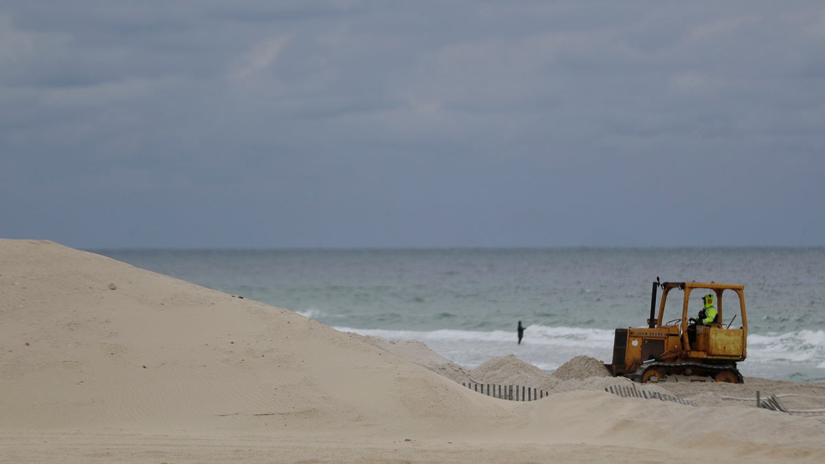 A worker pushes sand onto a protective sand dune in Seaside Heights