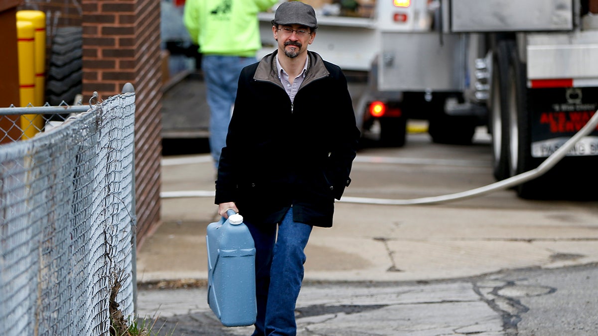  Tim Stuhldeher carries a container of water after filling it at a fire station in Pittsburgh’s Lawrenceville neighborhood on Feb. 1, 2017. After the state’s Department of Environmental Protection found low levels of chlorine at a city water facility, the subsequent flush-and-boil advisory affected 100,000 customers. Pittsburgh Mayor Bill Peduto announced on Wednesday that as Pittsburgh updates its aging water infrastructure, all city residents will receive a water filter. (AP Photo/Keith Srakocic)  