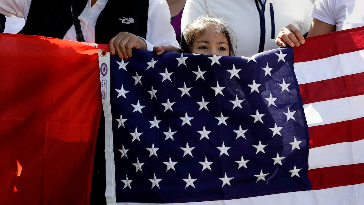  A young girl helps hold a U.S. flag as a group marches toward the Texas Capitol during an immigration protest last month in Austin, Texas. (AP Photo/Eric Gay) 