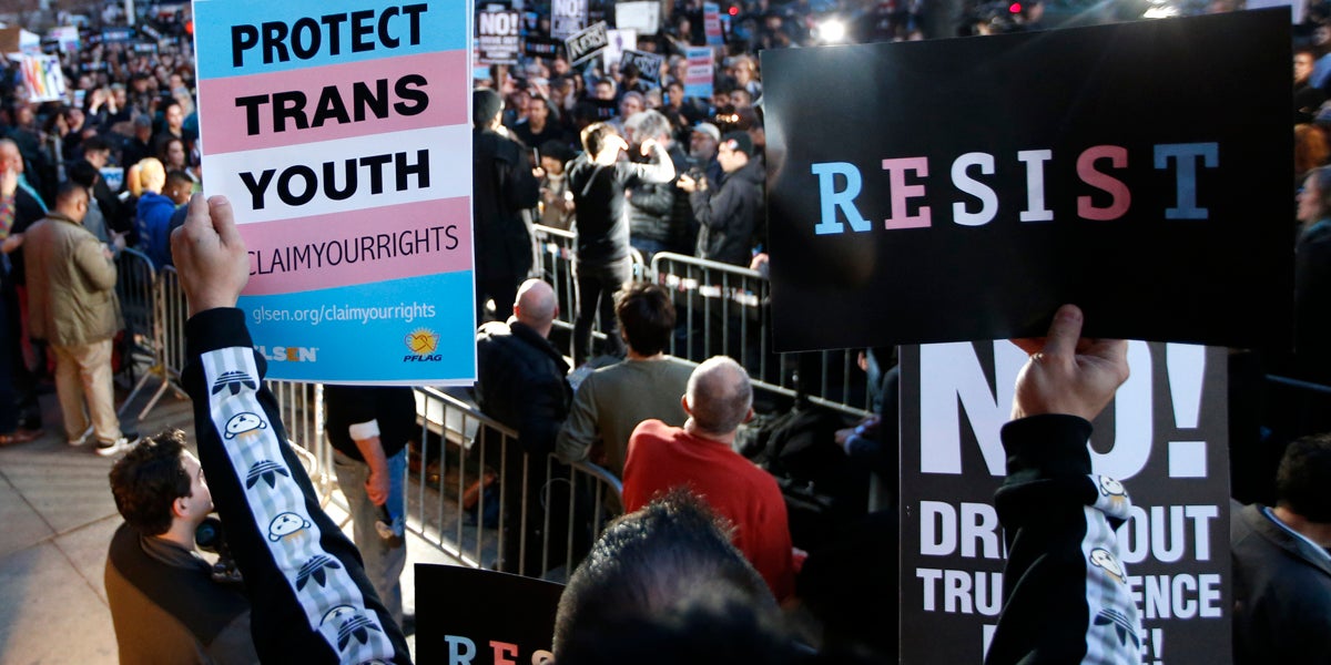  A participant holds signs from a stoop next door to the Stonewall National Monument during a rally in support of transgender youth Thursday in New York. Supporters spoke out against President Donald Trump's decision to roll back a federal rule saying public schools had to allow transgender students to use the bathrooms and locker rooms of their chosen gender identity. (AP Photo/Kathy Willens) 
