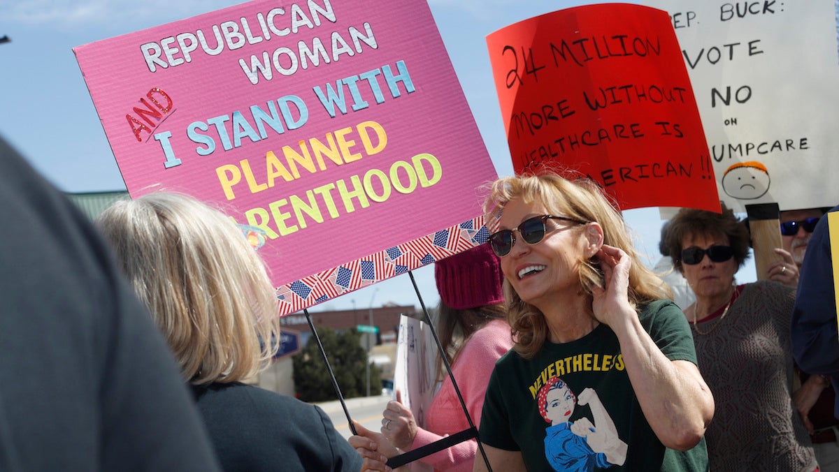  In this Wednesday, March 22, 2017 photo, Carolyn Williamson waves a placard in support of Planned Parenthood as she joins other protesters against the failed Republican health care act in a demonstration outside the office of U.S. Rep. Ken Buck in Castle Rock, Colo. (AP Photo/David Zalubowski) 