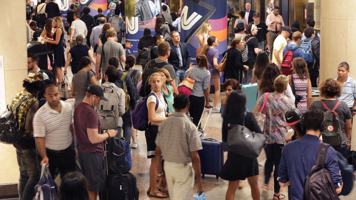  Passengers navigate the New Jersey Transit area in New York's Penn Station Tuesday. New Jersey Transit says some trains have been canceled this week because engineers are choosing not to work under the terms of their contract amid the summer-long repair work at Penn Station. (AP Photo/Richard Drew) 