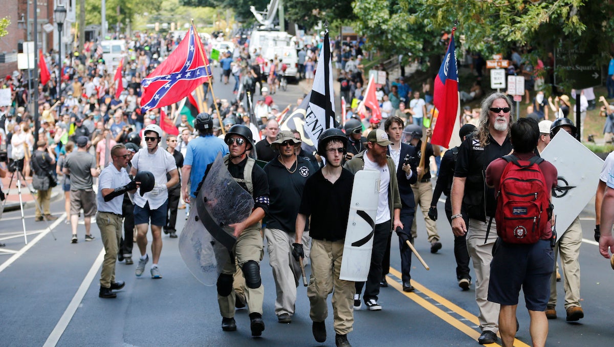  White nationalist demonstrators walk through town after their rally was declared illegal near Lee Park in Charlottesville, Va., Saturday, Aug. 12, 2017. (AP Photo/Steve Helber) 