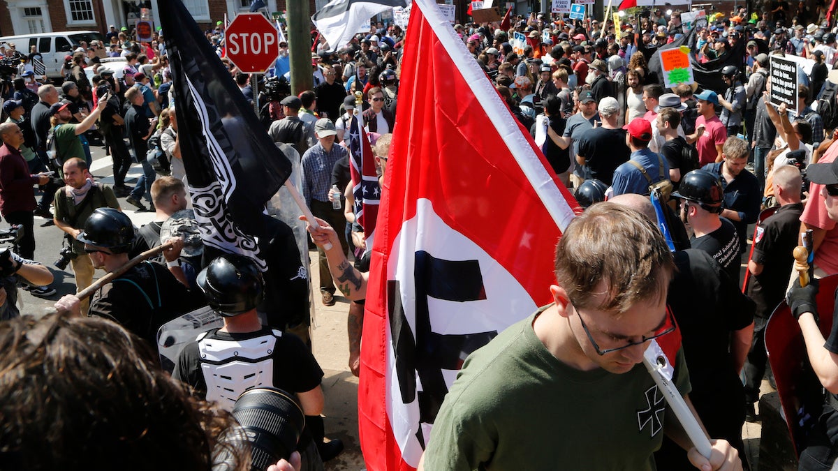 This Saturday, Aug. 12, 2017 image shows a white supremacist carrying a Nazi flag into the entrance to Emancipation Park in Charlottesville, Va. (Steve Helber/AP Photo) 