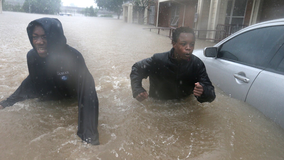  Friends Franklin Halloween, 16, left, and Deleon Gambel, 14, fight the current from the overflow of Buffalo Bayou as they make their way through floodwaters from Tropical Storm Harvey while checking on neighbors in their apartment complex in Houston, Texas, Sunday, Aug. 27, 2017. (AP Photo/LM Otero) 