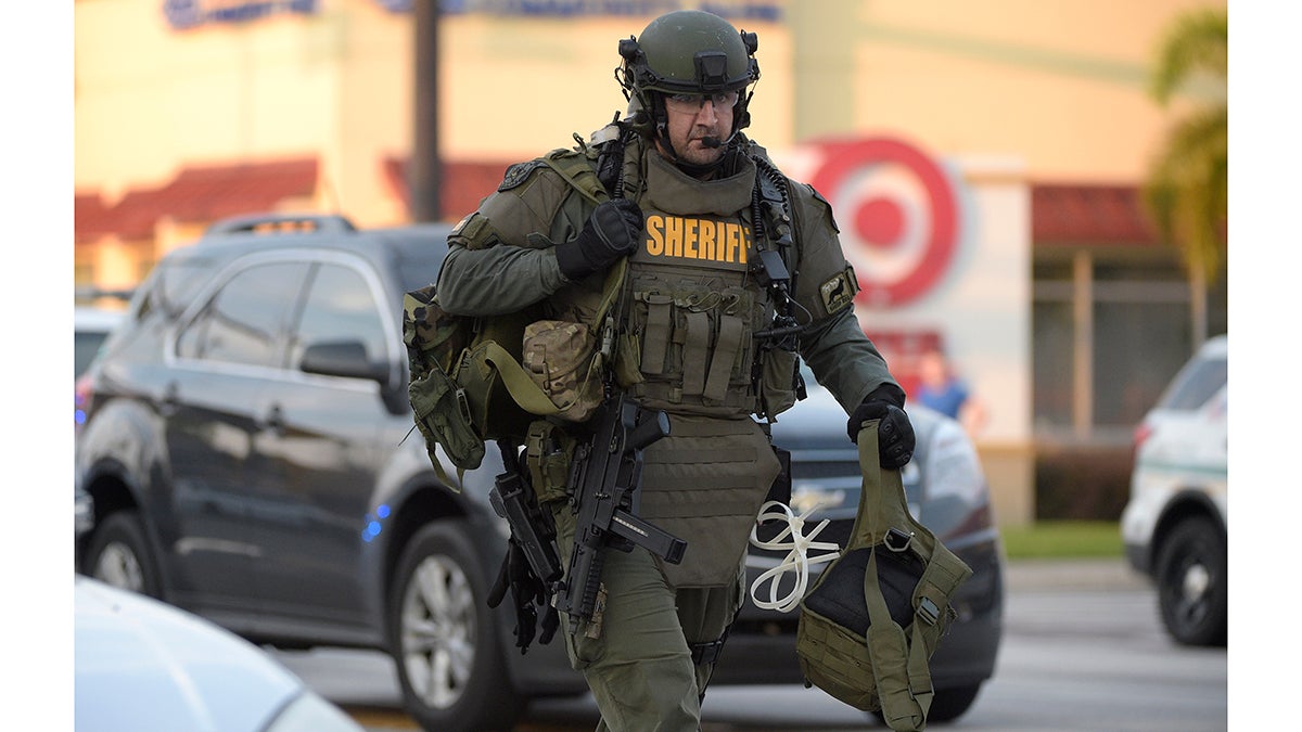 A police officer arrives down the street after a shooting involving multiple fatalities at the Pulse Orlando nightclub in Orlando