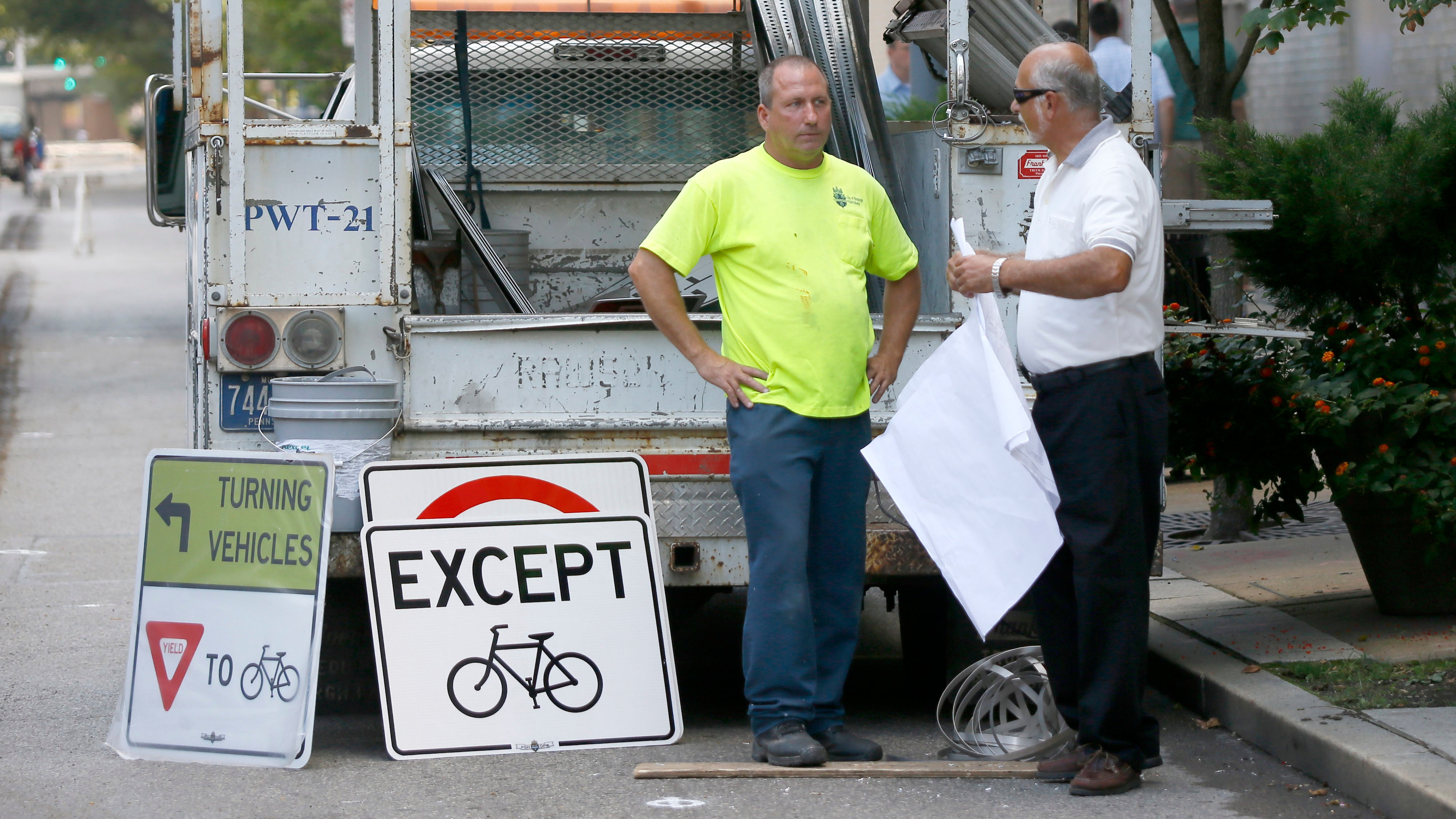  Public works employees prepare to change signs along the eastbound lane of Penn Ave. in downtown Pittsburgh, Pa. on Wednesday, Sept. 3, 2014. City officials closed the eastbound lane from 6th Street in downtown to 16th Street in the city's Strip District to motor vehicles and made it a protected bicycle lane. (AP Photo/Keith Srakocic) 