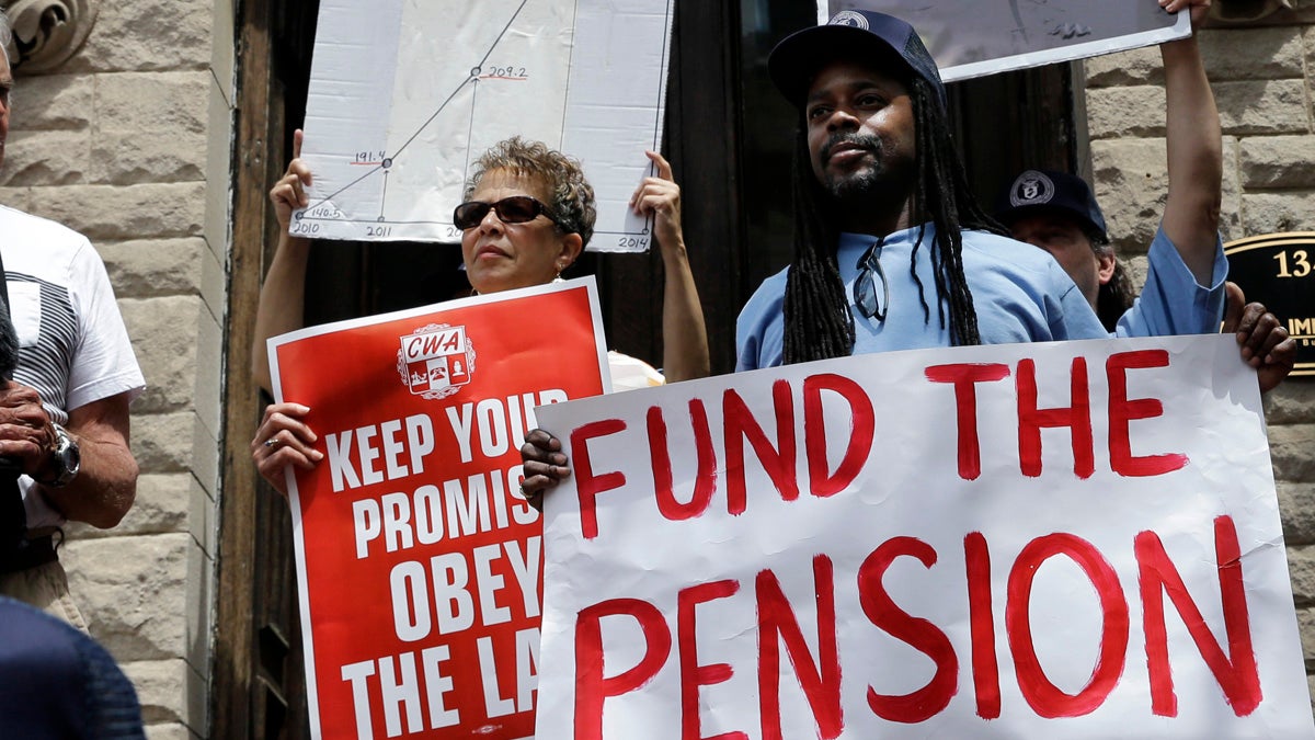 New Jersey public workers hold signs during a StateHouse rally  last year to protest Gov. Chris Christie's pension funding reductions. State lawmakers are considering a constitutional amendment to require quarterly state payments to the pension system. (AP Photo/Mel Evans)