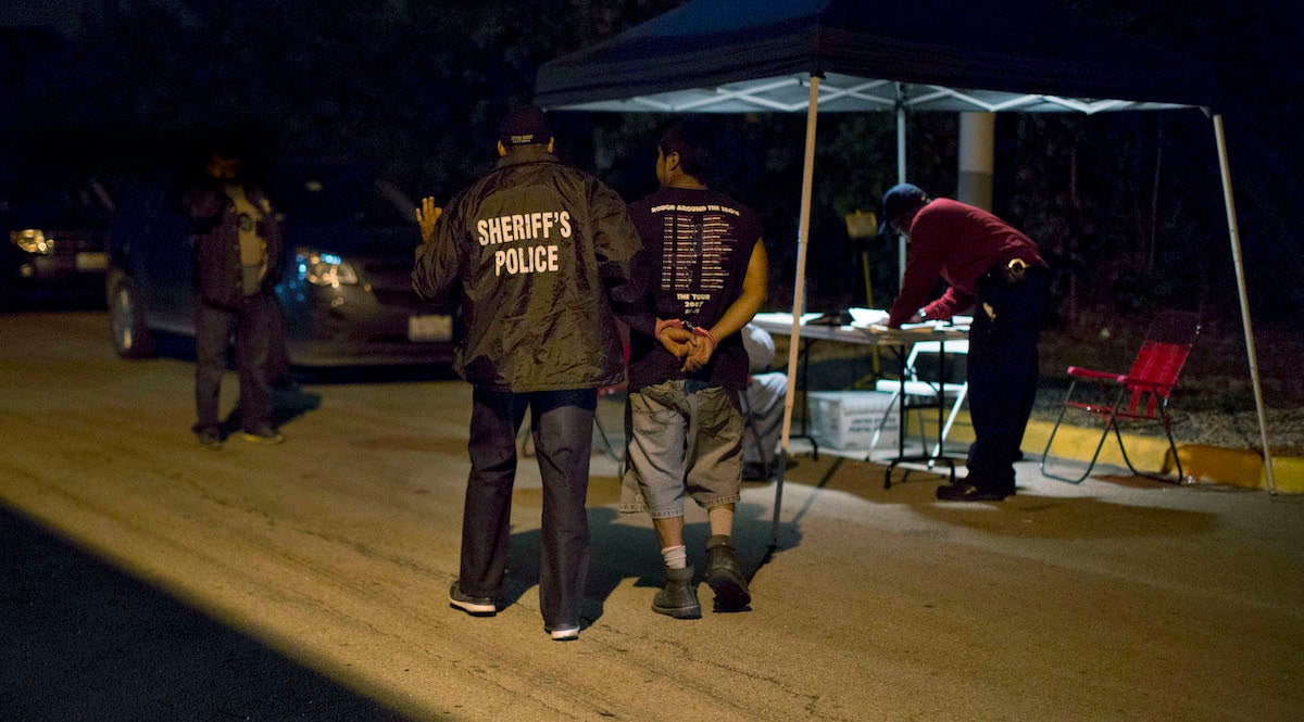  A 'john' who attempted to pick up an officer posing as a prostitute is escorted in handcuffs to a command post to be ticketed during a prostitution sting in Cicero, Ill. on Thursday, Aug. 15, 2013. (AP Photo/Scott Eisen) 