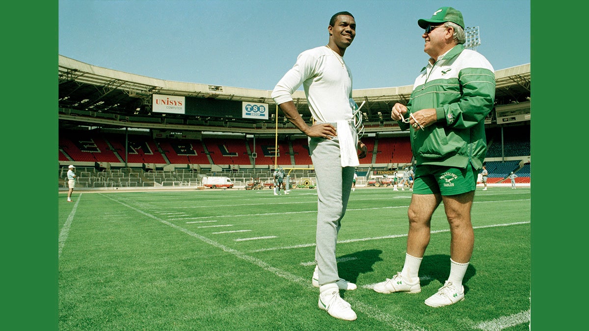  Randall Cunningham, quarterback for the Philadelphia Eagles talks with head coach Buddy Ryan during a light training session, Aug. 5, 1989, at London's Wembley Stadium where they took on the Cleveland Browns for the 1989 American Bowl. (AP Photo/Gillian Allen) 