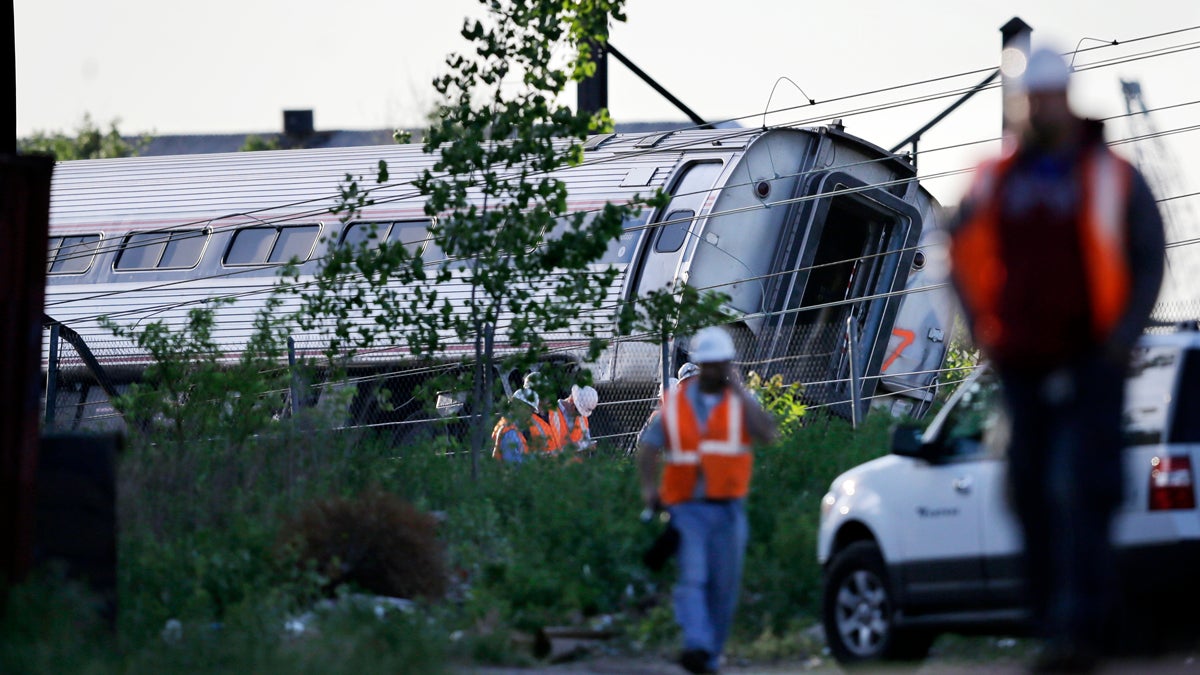 Emergency personnel walk near the scene of a deadly train wreck, Wednesday, May 13, 2015, in Philadelphia. An Amtrak train headed to New York City derailed and crashed in Philadelphia on Tuesday night. (AP Photo/Mel Evans)