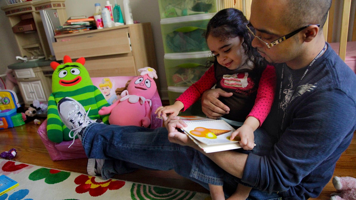  Christopher Astacio reads with his daughter Cristina, 2, diagnosed with a mild form of autism, in her bedroom in this Wednesday, March 28, 2012 file photo in New York. (Bebeto Matthews/AP Photo) 