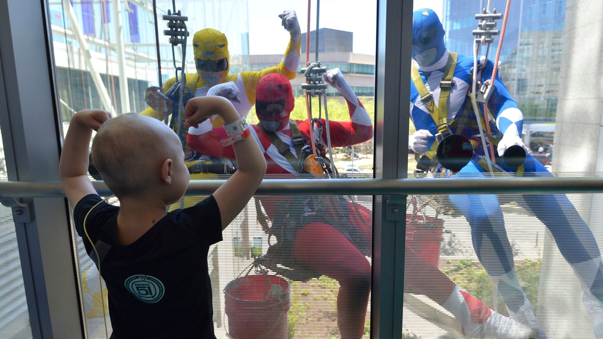  A patient at the Children's Hospital of Philadelphia flexes her muscles for window washers dressed up as Power Rangers on Tuesday, April 18, 2017. (HSE Photography/CHOP Photo) 