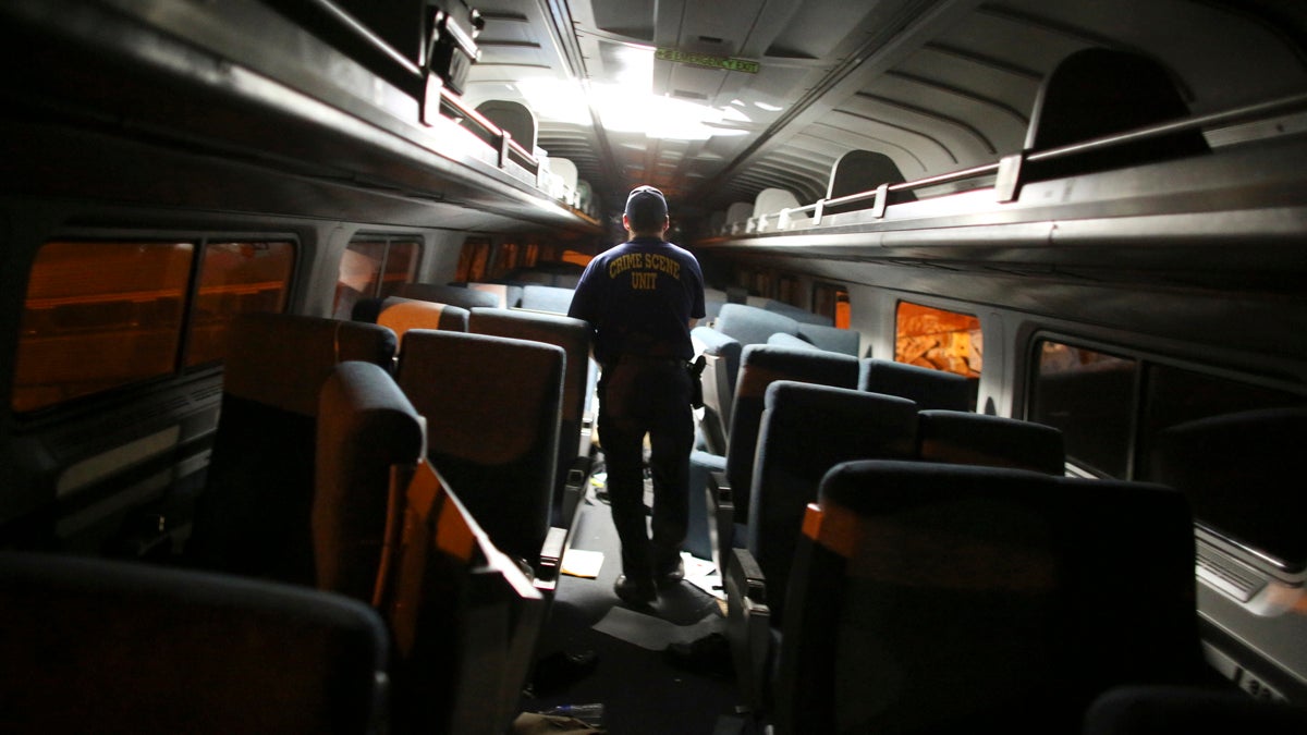 A crime scene investigator looks inside a train car after a train wreck, Tuesday, May 12, 2015, in Philadelphia. An Amtrak train headed to New York City derailed and crashed in Philadelphia.