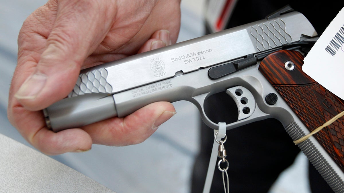 An exhibitor displays a .45 cal Smith & Wesson pistol. (Keith Srakocic/AP Photo)