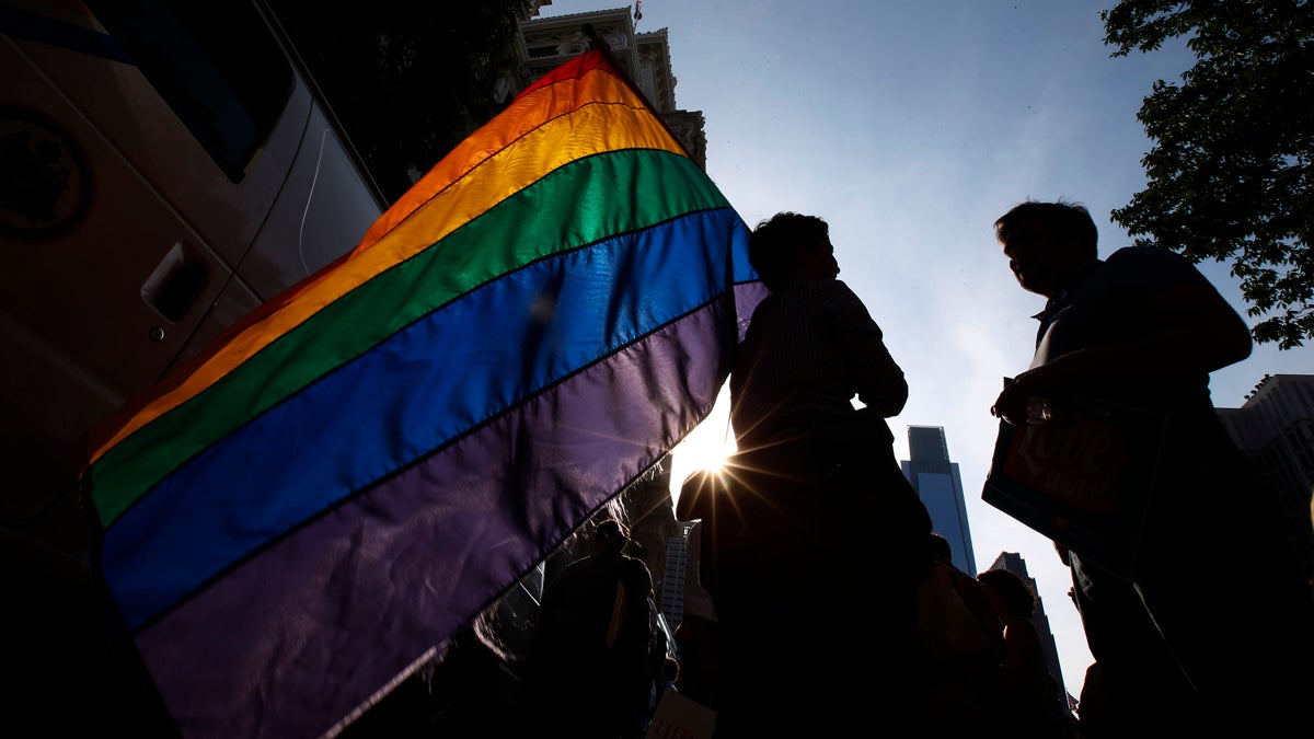  A person holds a rainbow-colored gay pride flag during a rally at Philadelphia City Hall in May 2014, following the overturning of the ban on same-sex marriage in Pennsylvania by a federal judge. (AP Photo/Matt Slocum) 