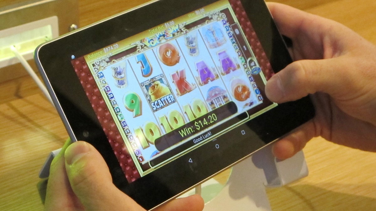 A person plays a slot on a touch-screen tablet