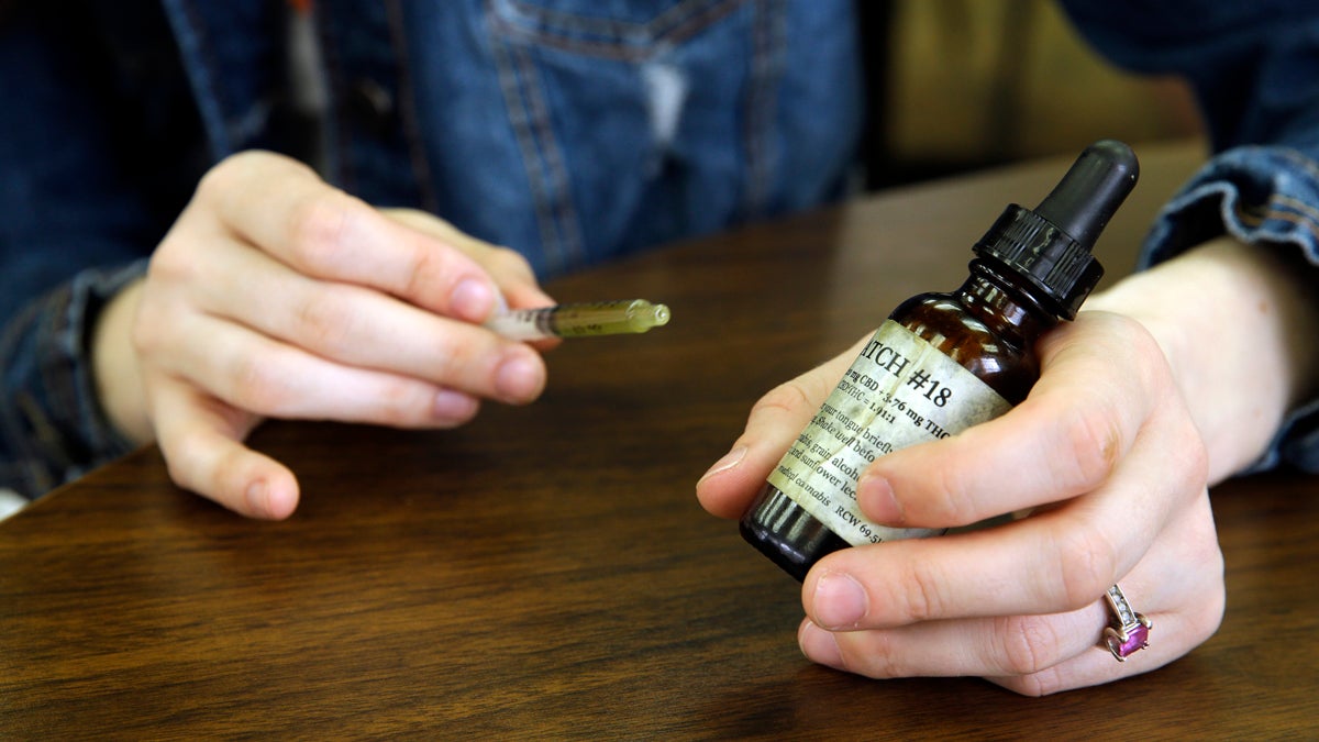  In this Tuesday, March 28, 2017 photo, Meagan Holt holds a vial of cannabis oil she uses to comfort her daughter Maddie, Tuesday, March 28, 2017, after they attended a hearing at the Capitol in Olympia, Wash., for House Bill 1060, which would allow parents or guardians to administer medical marijuana to children while at school or on a school bus. Maddie has a terminal genetic disease called Zellweger Syndrome, and used to have hour-long seizures, but Holt says that Maddie has found relief after treatment with cannabis oil and other pharmaceuticals. (Ted S. Warren/AP Photo) 