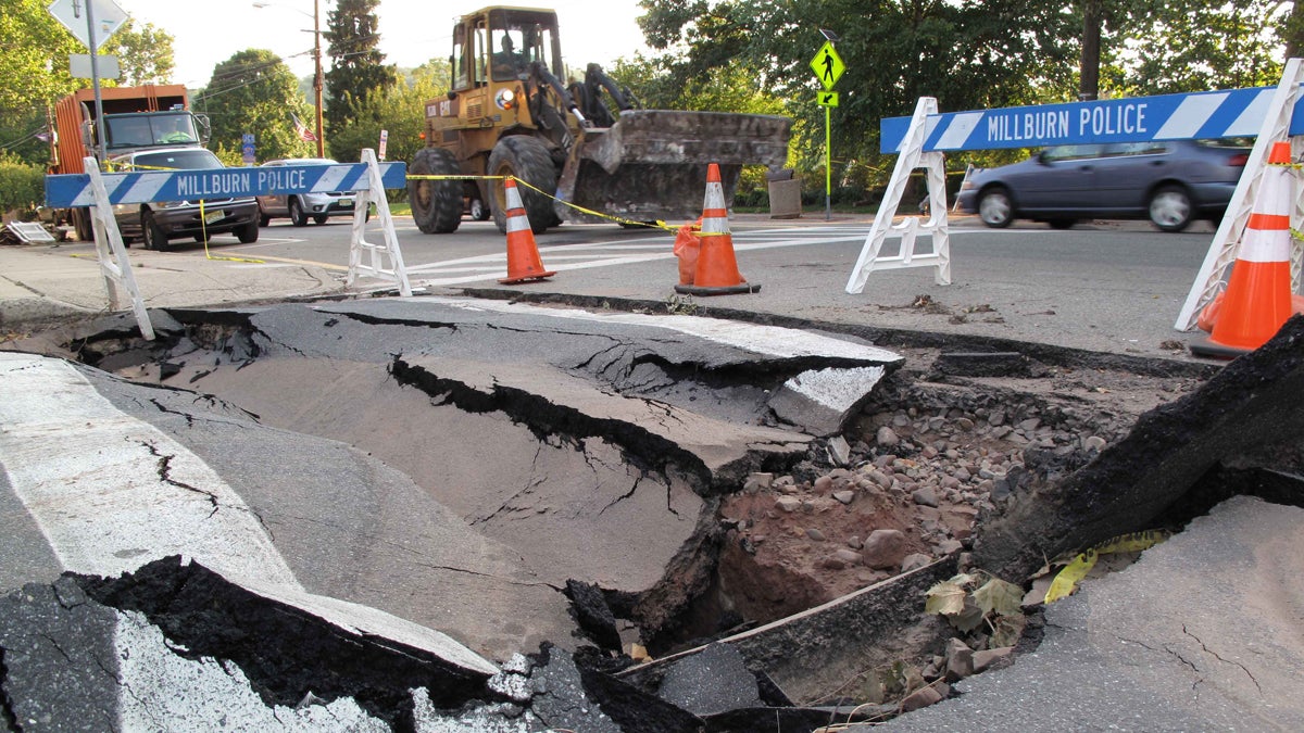  In this Sept. 2, 2011 photo, a front loader passes a sink hole in a Millburn, N.J. intersection. (Chris Hawley/AP Photo) 