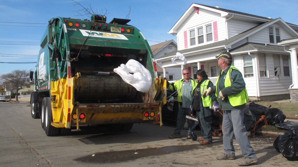  This file photo shows public works employees tossing waterlogged bedding into a garbage truck in Point Pleasant Beach N.J. (Wayne Parry/AP Photo) 