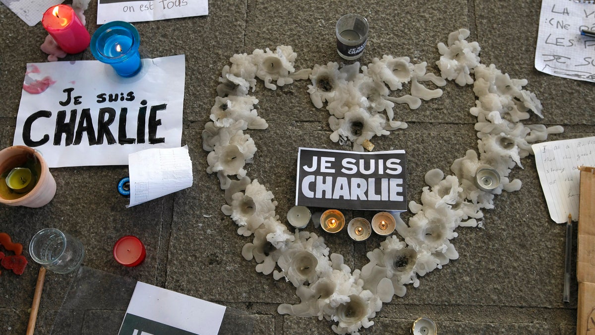  A heart formed by melted candles is on the ground of the Old-Port to pay tribute to the victims of the satirical newspaper 'Charlie-Hebdo,' in Marseille, southern France, Thursday, Jan. 8, 2015, a day after masked gunmen stormed the offices of a satirical newspaper and killed 12 people. French police hunted Thursday for two heavily armed men — one with a terrorism conviction and a history in jihadi networks — in the methodical killing of 12 people at a satirical newspaper that caricatured the Prophet Muhammad. (Claude Paris/AP Photo) 