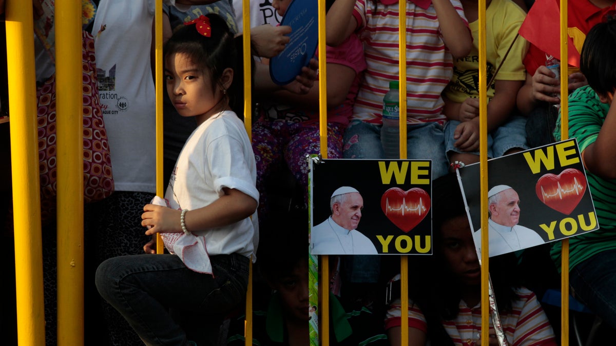  A young girl waits behind a fence for hours for the arrival of Pope Francis in Manila, Philippines, Thursday, Jan. 15, 2015. (Wally Santana/AP Photo) 