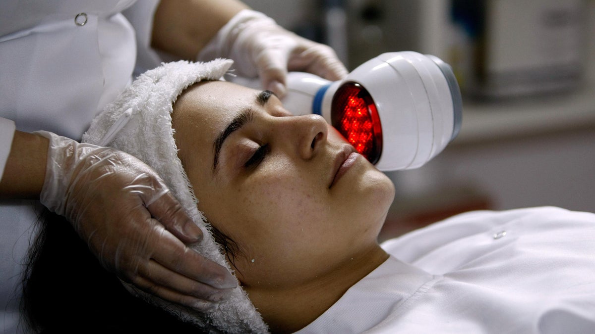 A doctor uses a machine to heat up the skin of a patient receiving treatment to lighten her skin (Hassan Ammar/AP Photo)