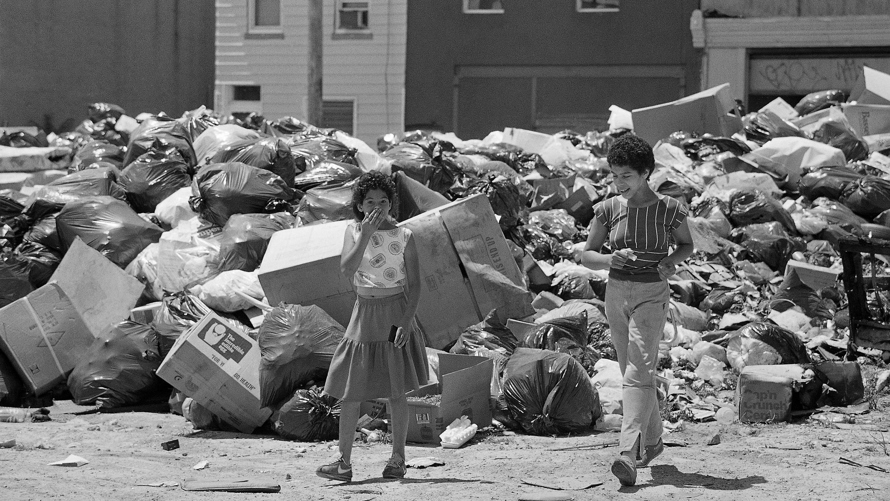 Marybel Colon, 10, of Philadelphia holds her mouth and nose while cutting through a temporary dumpsite in her neighborhood in Philadelphia, July 15, 1986, due to the strike by municipal workers. The strike is in its third week. (AP Photo/Charles Krupa)