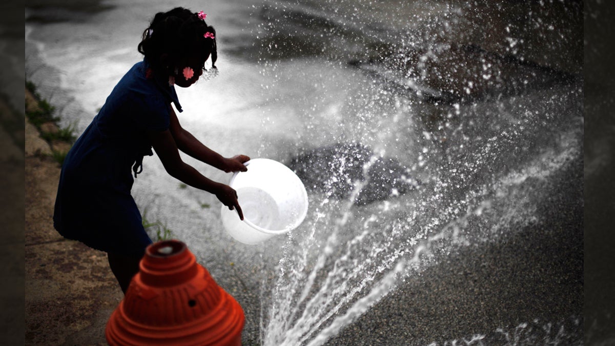  In this July 18, 2012 file photo, Jazia Pratt, 8, fills a bucket with water from a fire hydrant in the afternoon summer heat in Philadelphia. (Matt Rourke/AP Photo) 